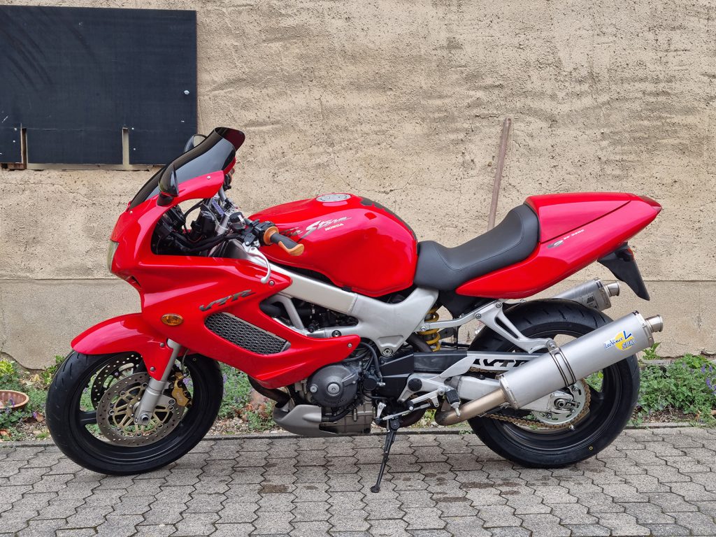 Rote Honda VTR 1000 F Firestorm Motorrad in Seitenansicht mit Leovince SBK Sportauspuff und Soziusabdeckung