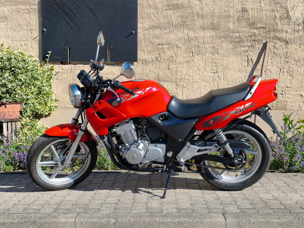 Gepflegtes Naked Bike Honda CB500 in Rot mit silbernen Felgen, Seitenansicht auf dem Hauptständer. Fahrbereites Motorrad zum Verkauf bei BaxiMoto-Motorradhandel Inh. Sebastian Marschalt in Kitzscher